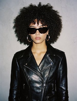 Porträt einer Frau mit Sonnenbrille und Lederjacke.