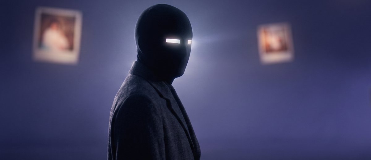 Final design: a figure in a dark coat with a smooth matte black head and a single thin bar of white light for eyes, in violet fog with photographs
