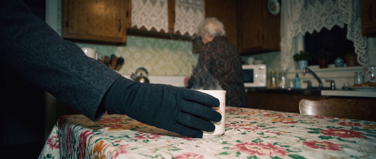 End frame: the gloved hand closed gently around the steaming mug