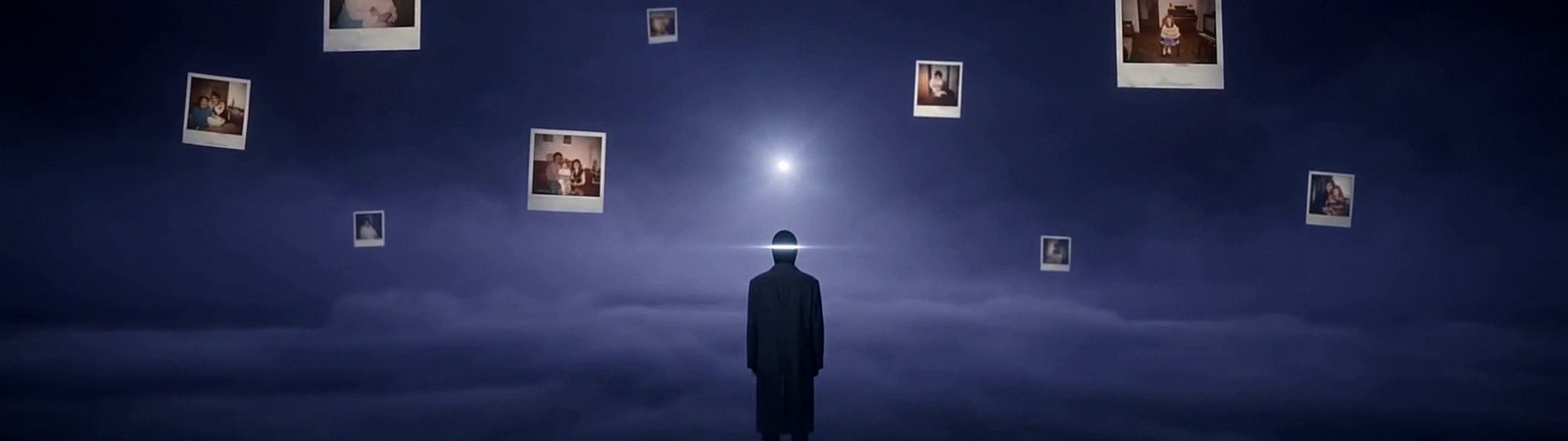 A small figure in a long dark coat stands in an endless violet fog under a single cold light, with family photographs hanging motionless in the air